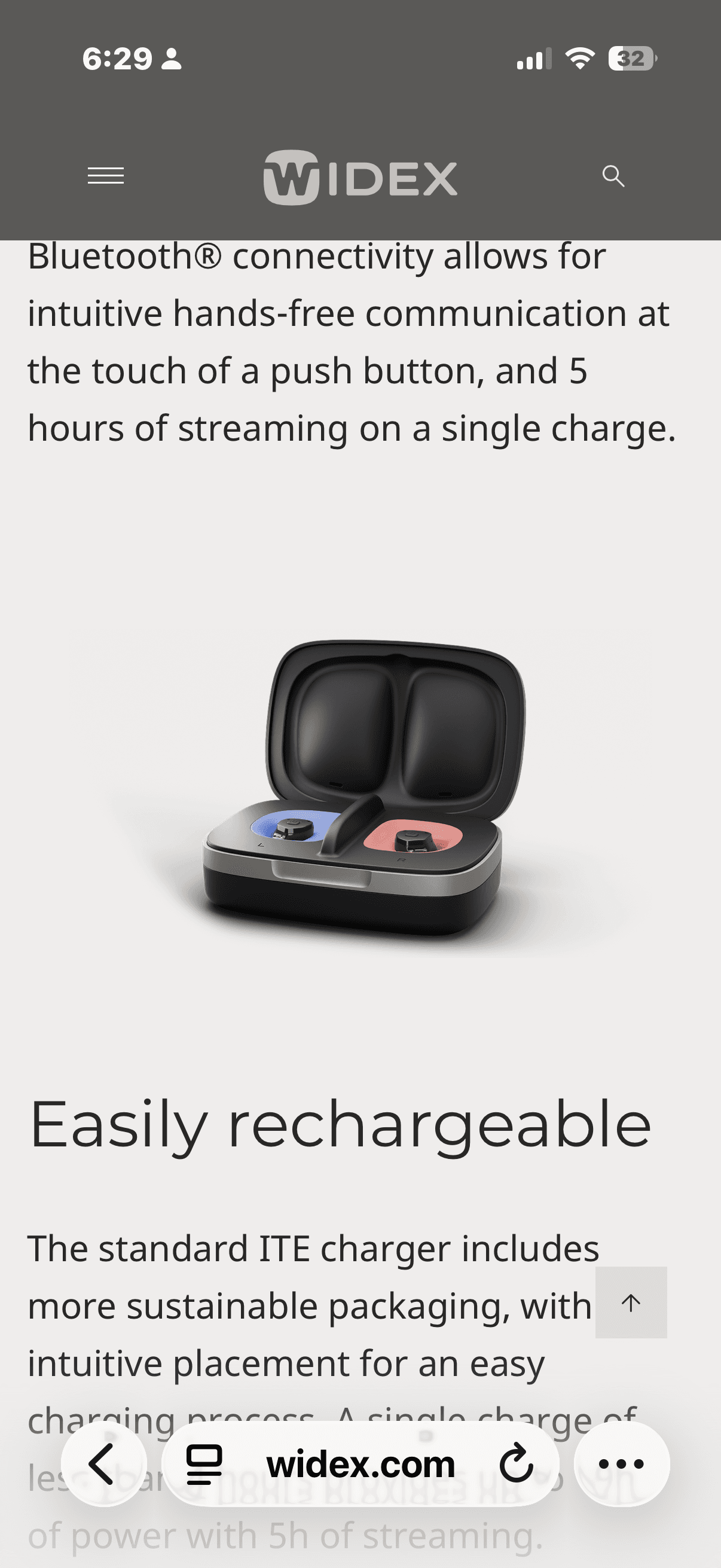 Open black charging case with blue and red in-the-ear hearing aids inside.
