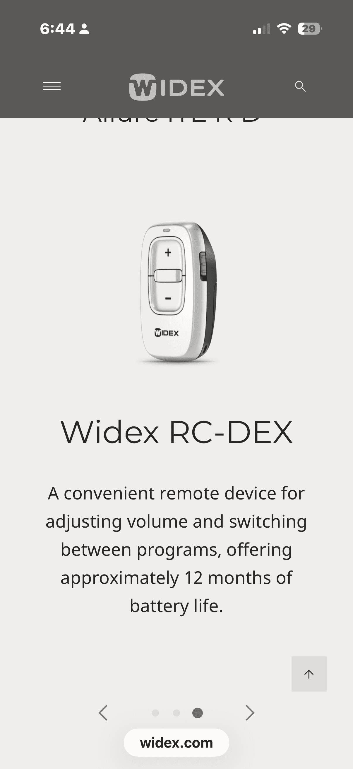 Small white Widex RC-DEX remote control for adjusting hearing aid volume and switching programs.