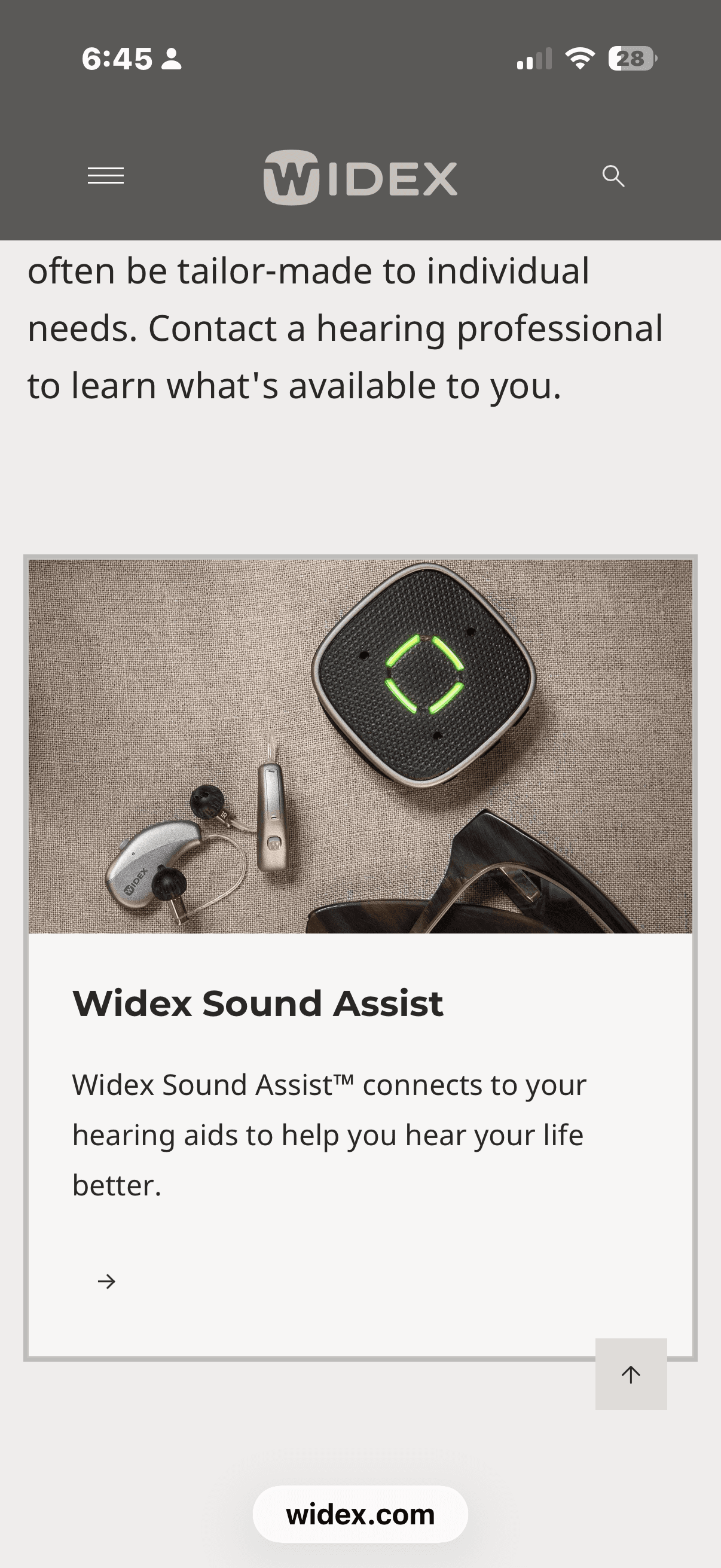 Widex Sound Assist device with a green glowing ring next to two silver hearing aids.